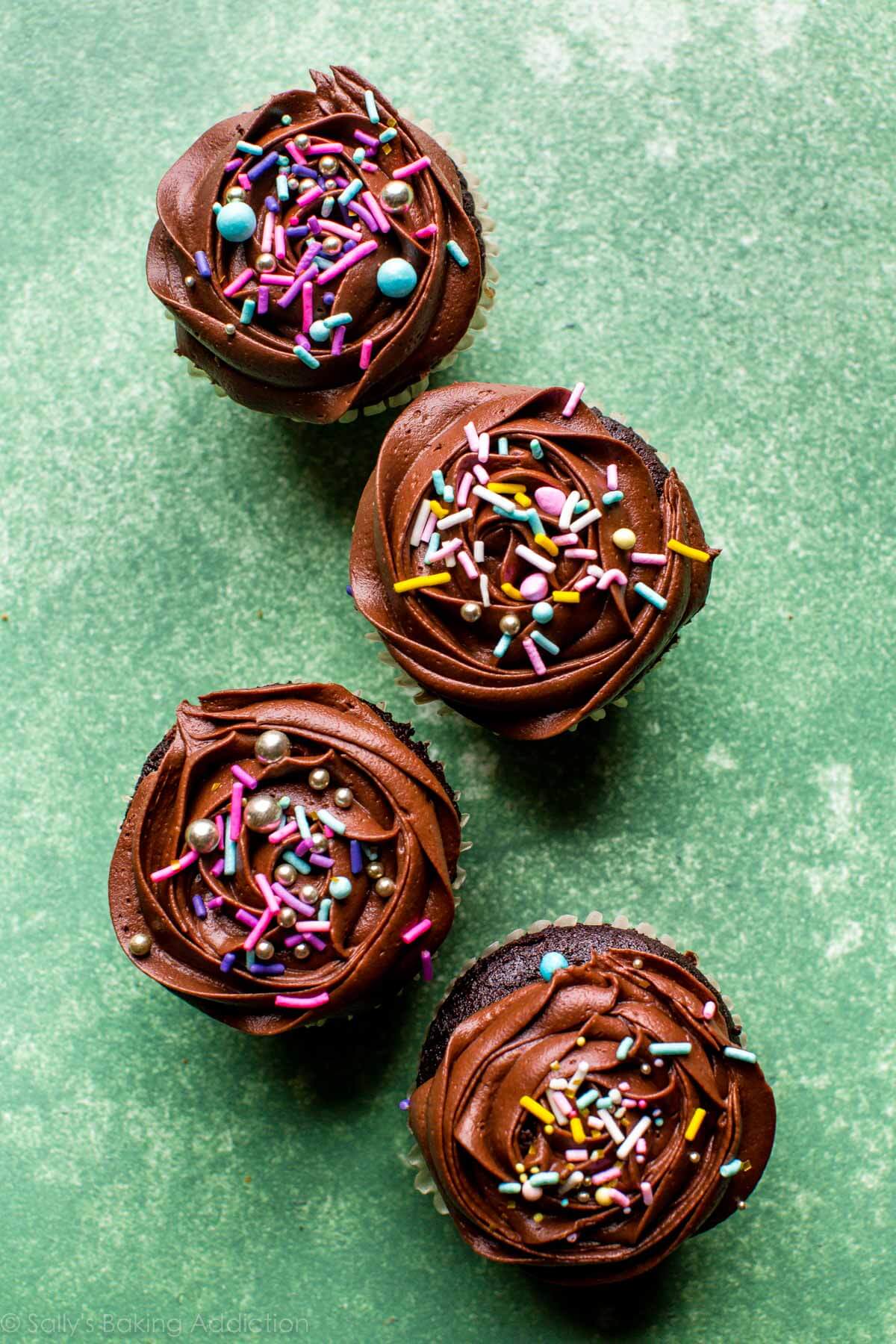 overhead image of chocolate cupcakes topped with chocolate buttercream and sprinkles