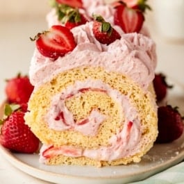 strawberry cake roll with strawberries on top.