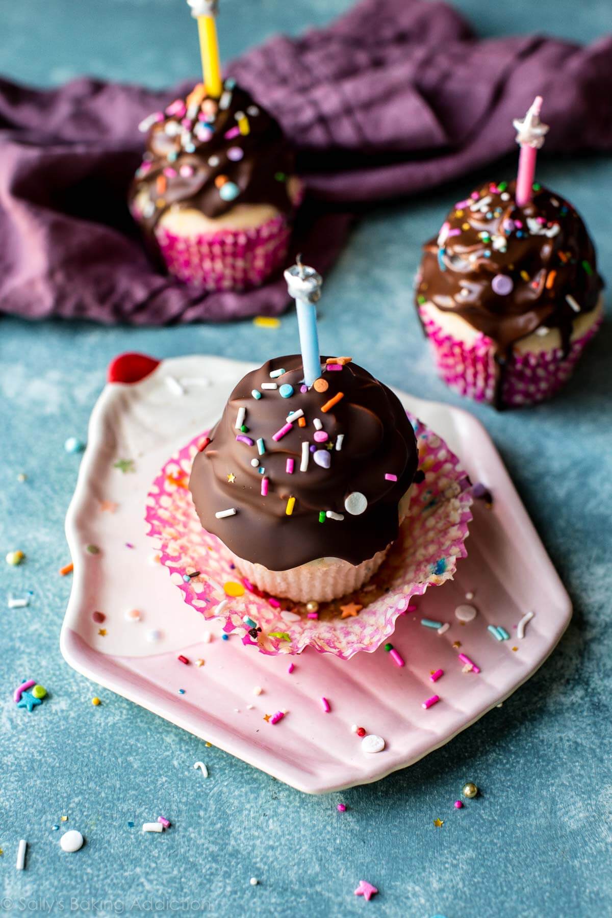 birthday cupcakes with chocolate coating, sprinkles, and candles