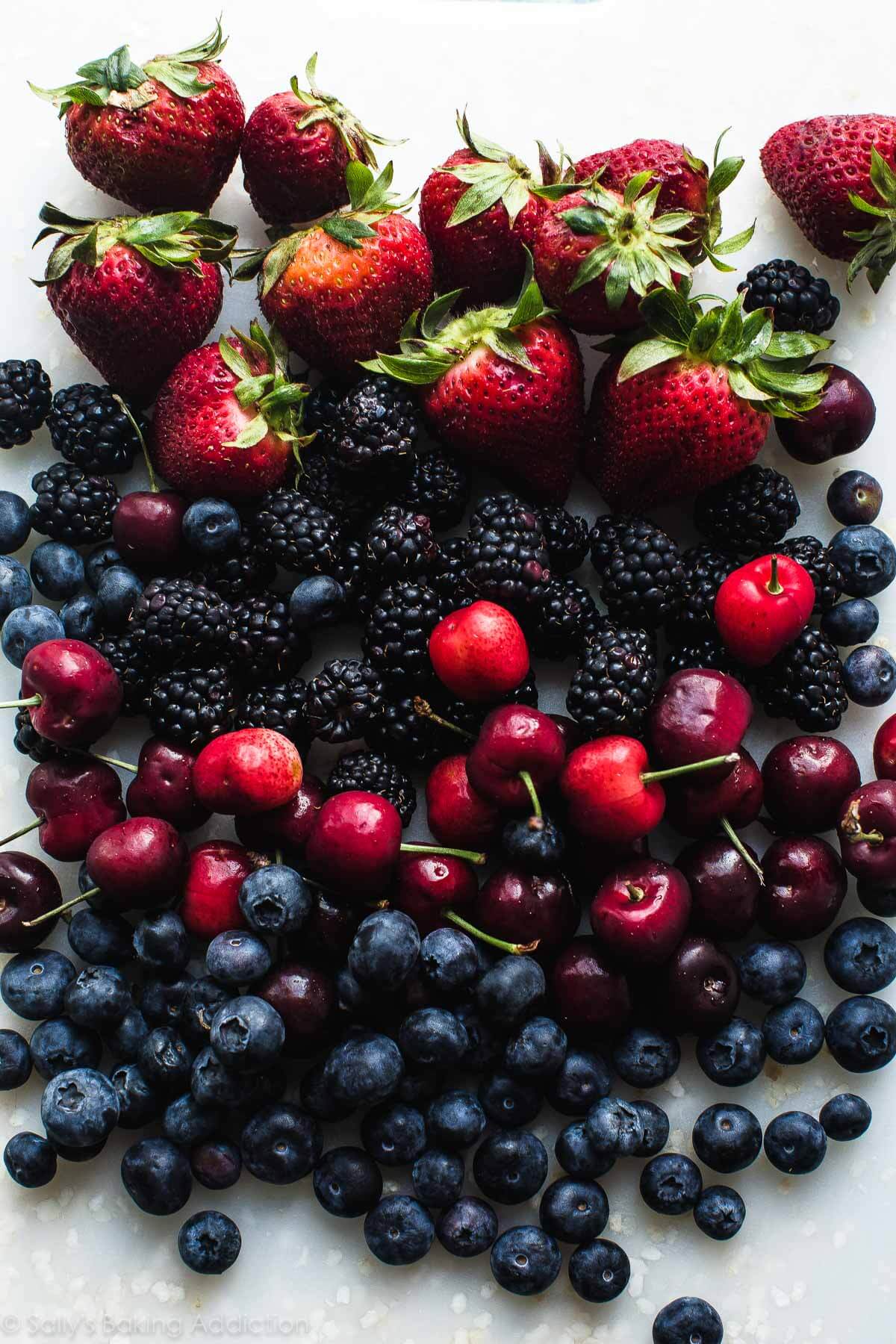 mixed berries on a white cutting board