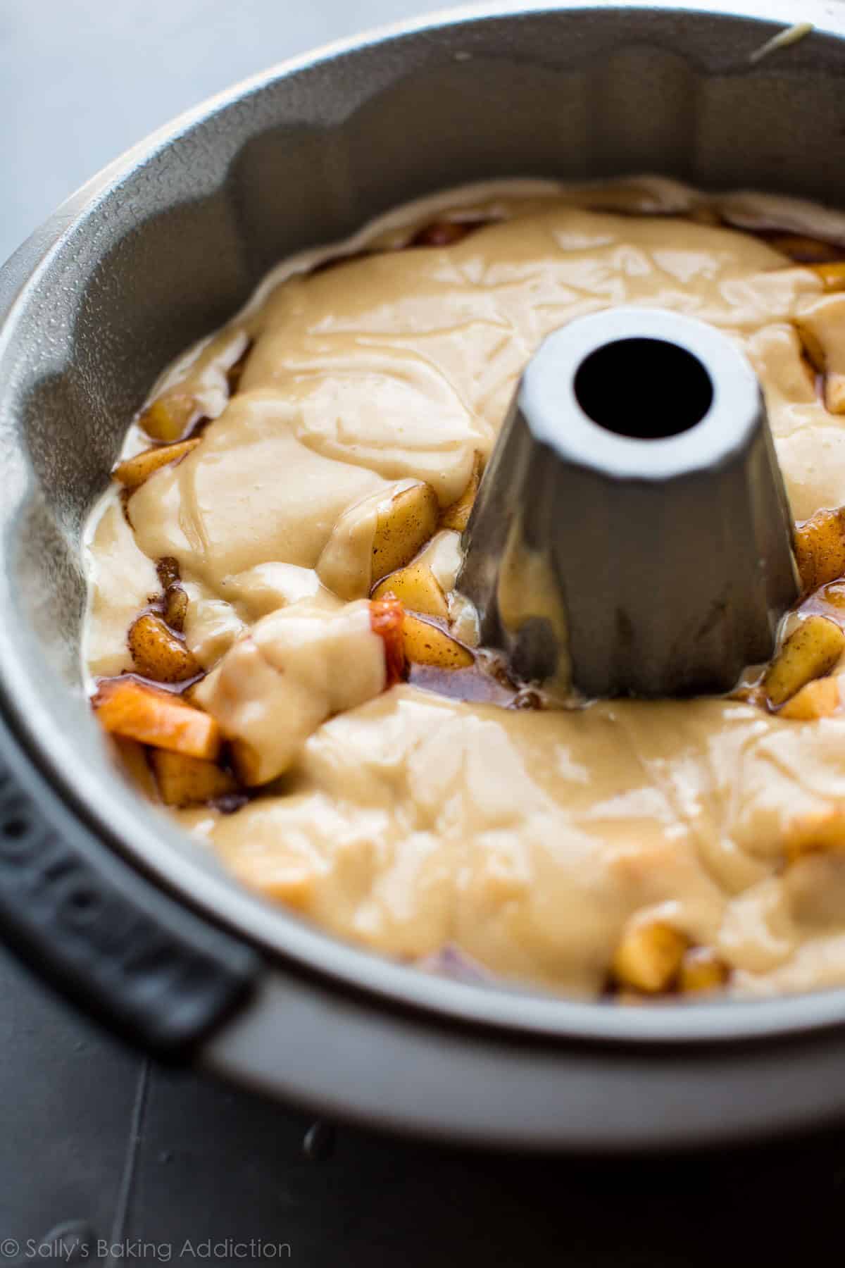 close up image of peach bundt cake batter in a bundt pan