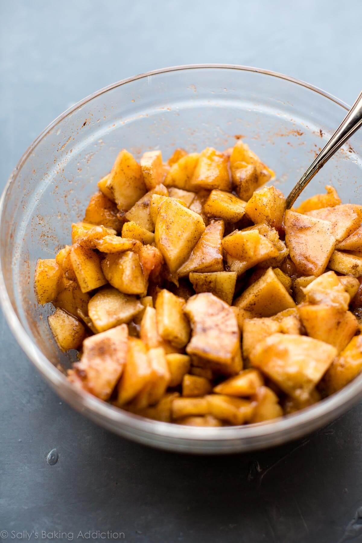 chopped peaches with cinnamon and sugar in a glass bowl