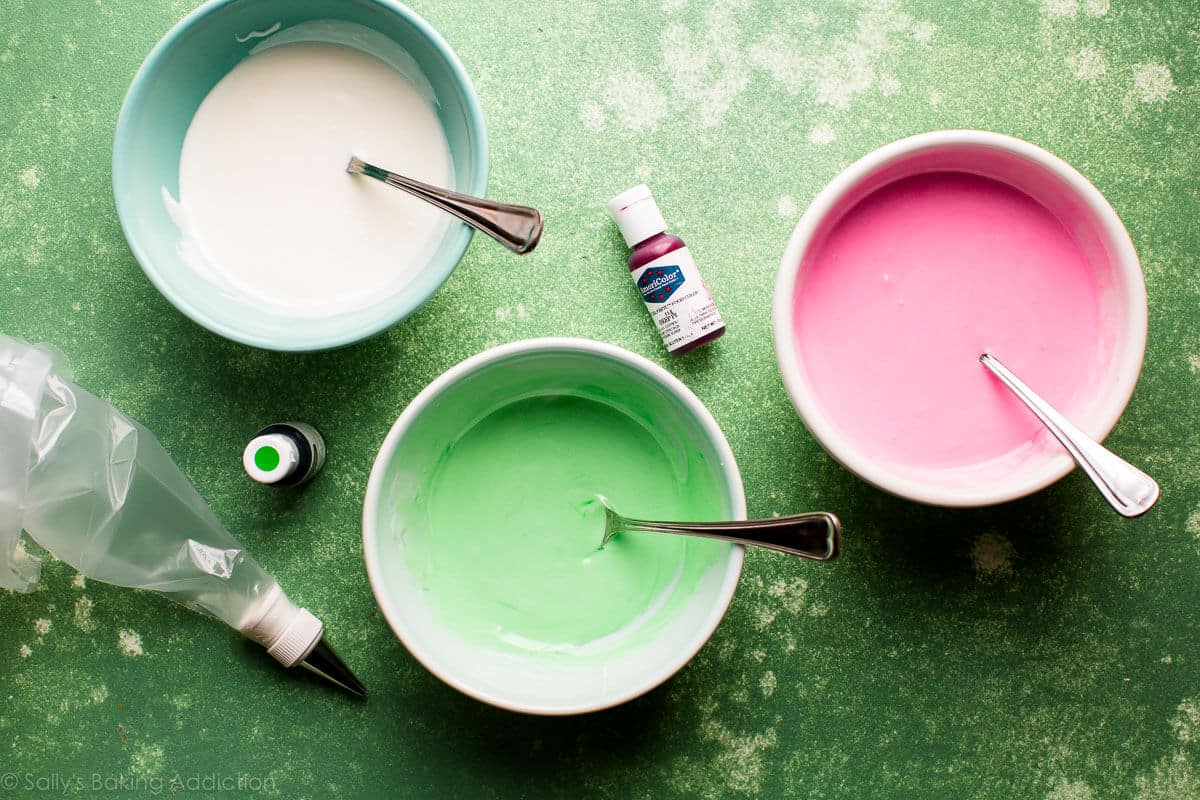 bowls of pink, green, and white royal icing