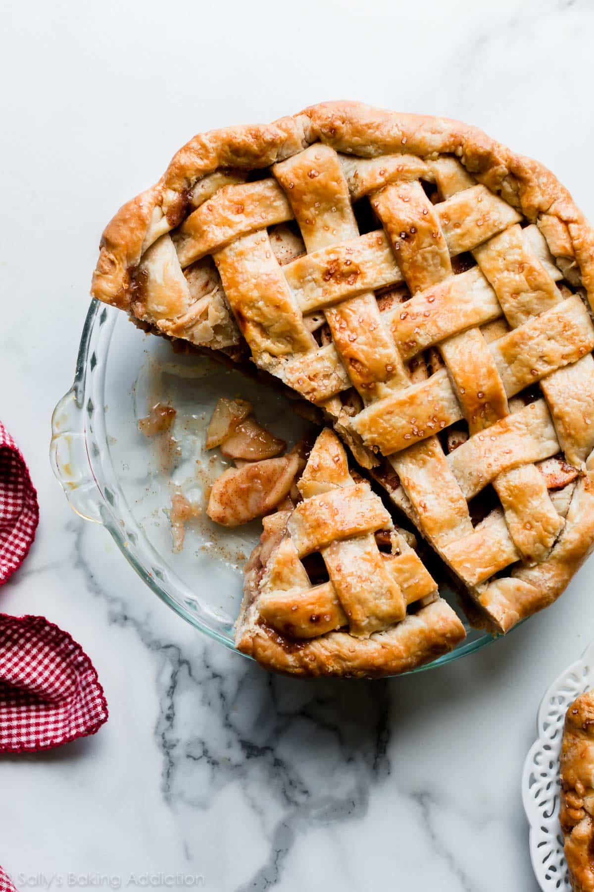 Deep dish apple pie with lattice pie crust with a slice cut out