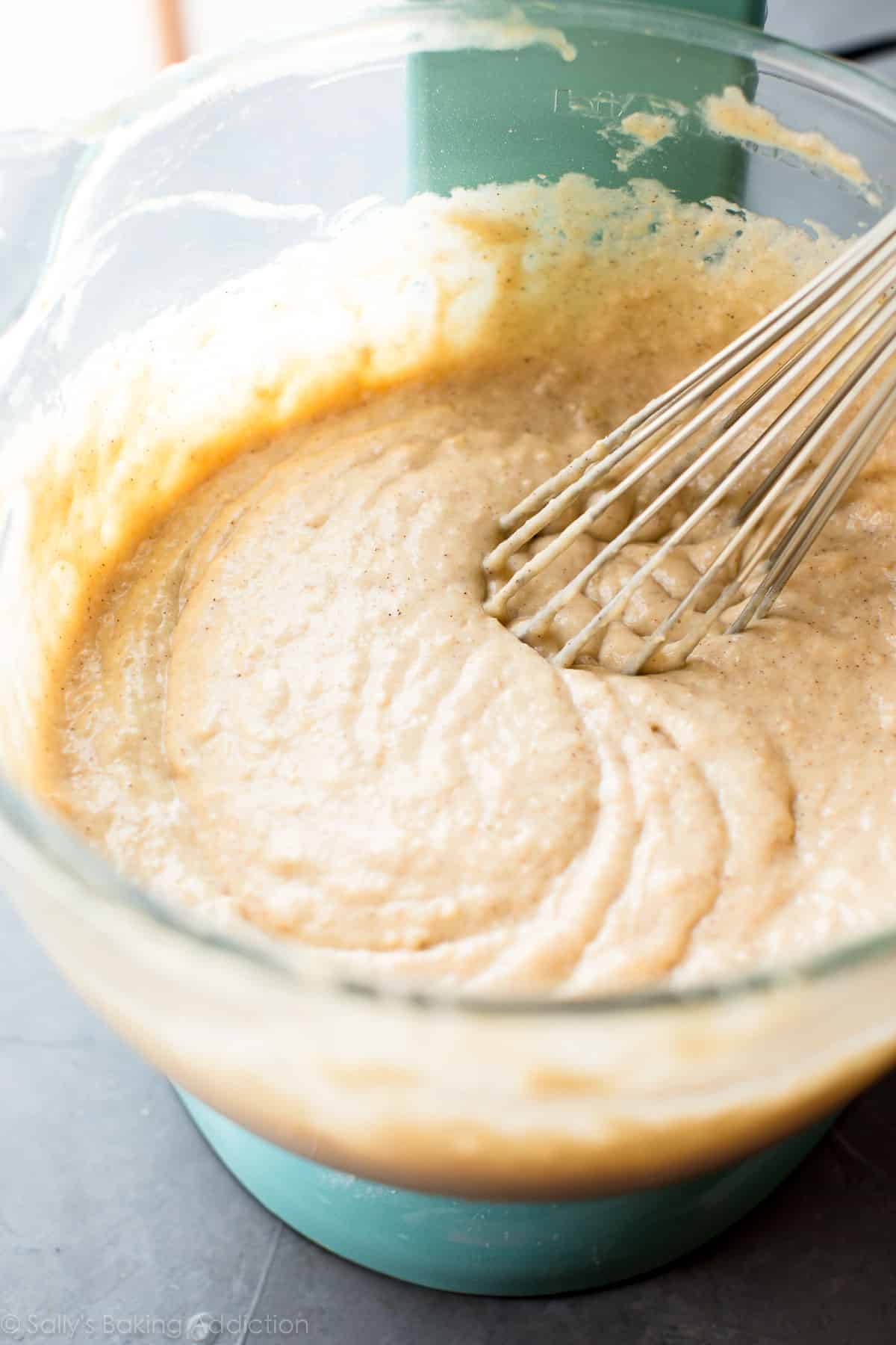 banana cake batter in a glass bowl with a metal whisk