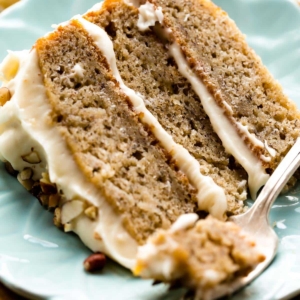 slice of banana layer cake on a light blue plate with a fork