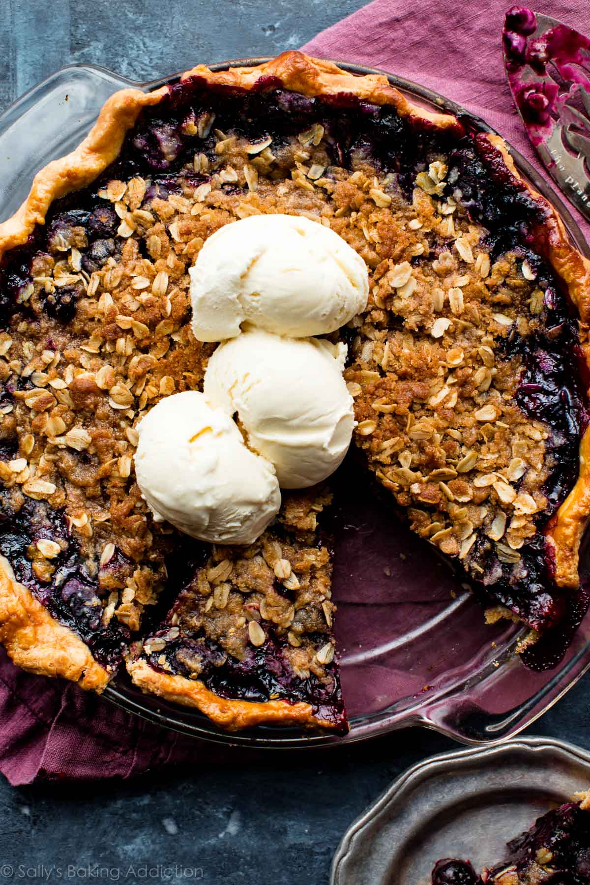 overhead image of blueberry crumble pie with scoops of vanilla ice cream on top