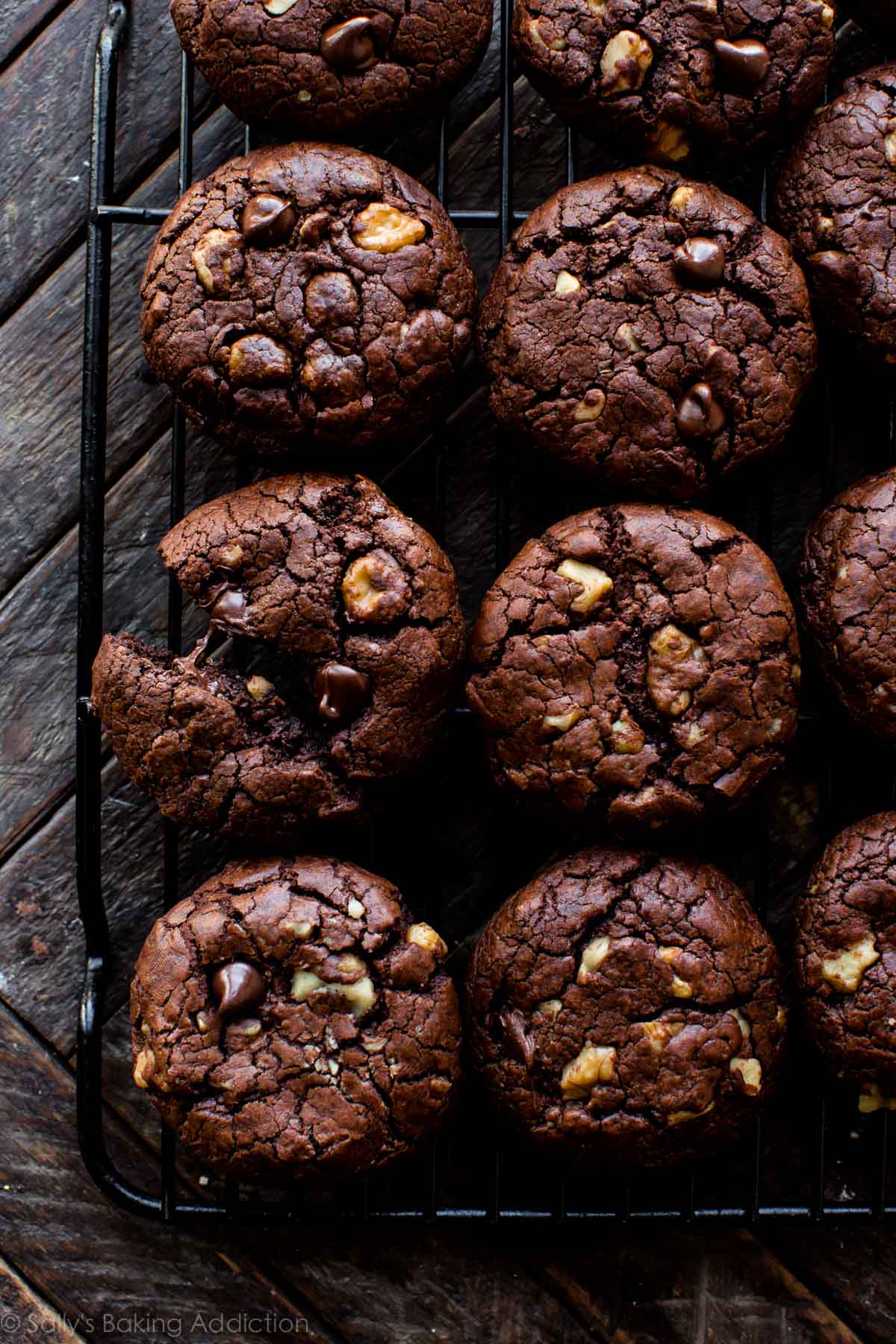 overhead image of brownie walnut cookies on a black cooling rack