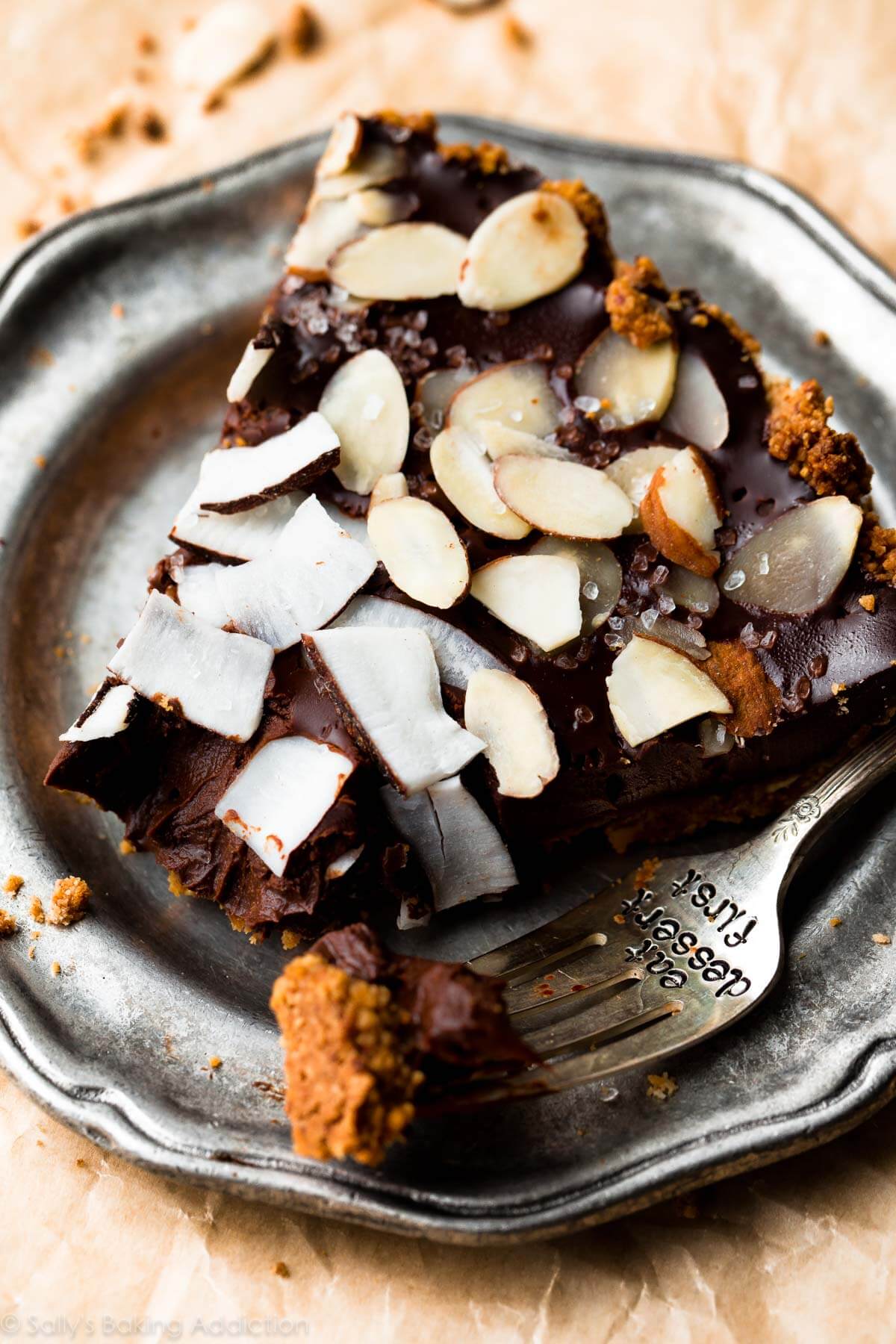 slice of chocolate coconut almond tart on a silver plate with a fork