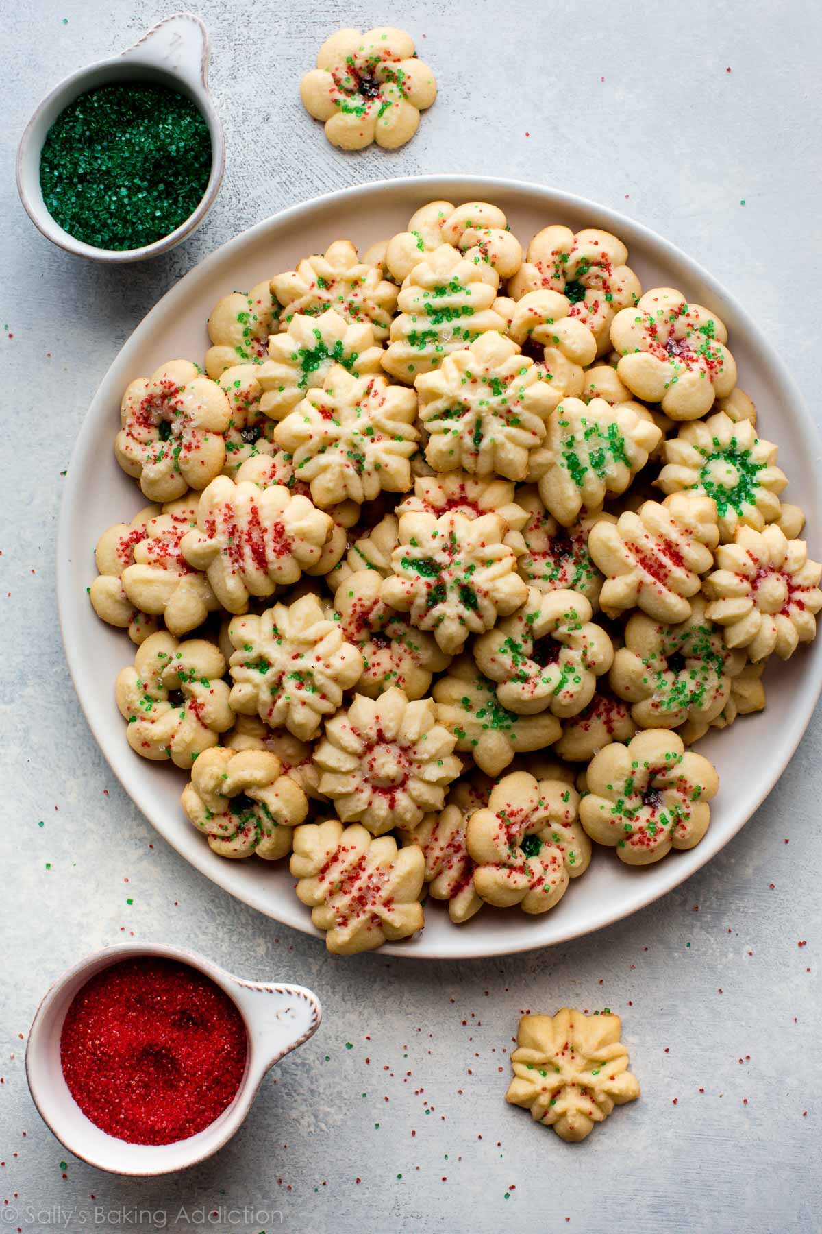 spritz cookies with red and green sprinkles on a white plate
