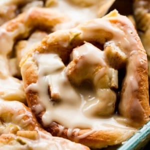 zoomed in image of apple cinnamon rolls in a glass baking dish