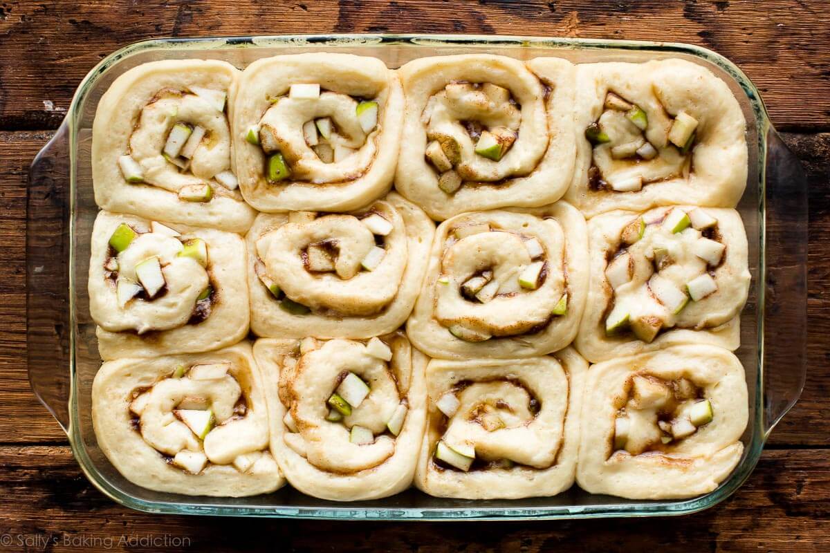 apple cinnamon rolls in a 9x13 glass baking dish after rising