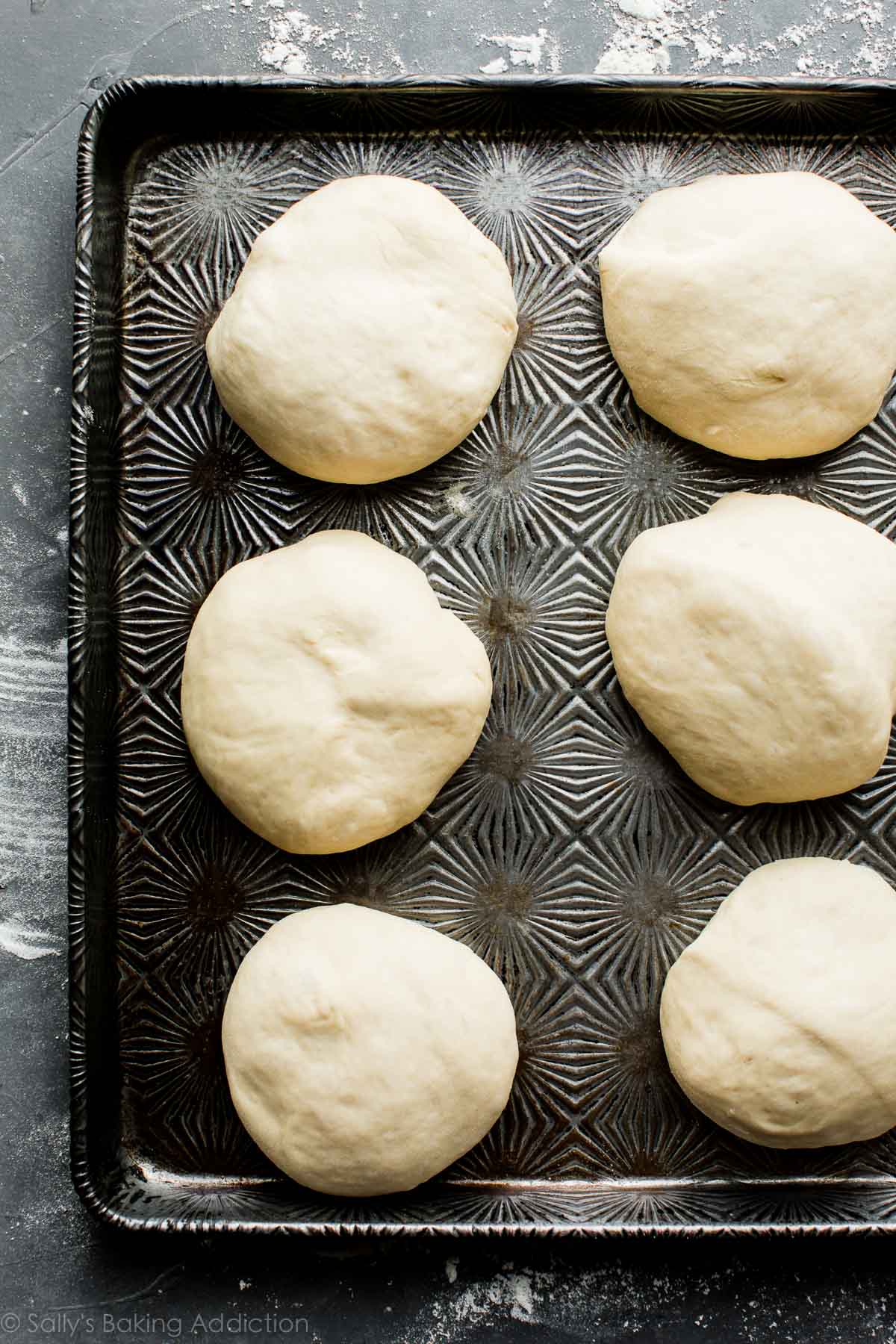 pretzel roll dough shaped into rolls on a baking sheet