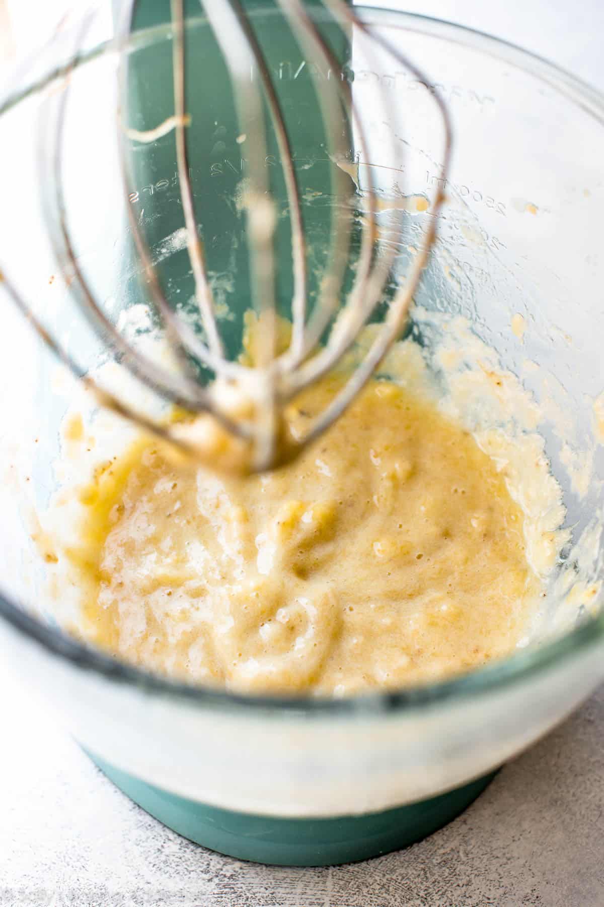 mashed bananas in a glass stand mixer bowl