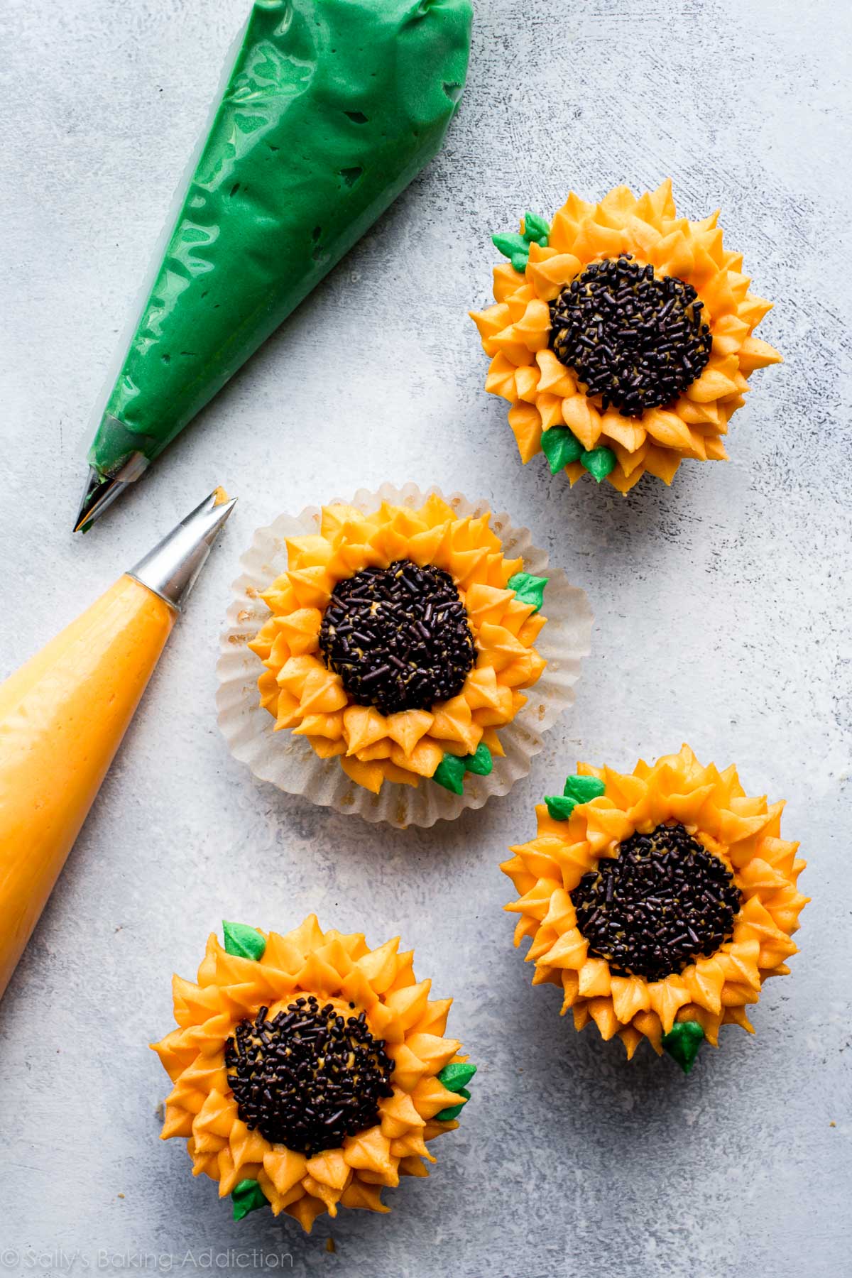 sunflower cupcakes with yellow and green buttercream in piping bags