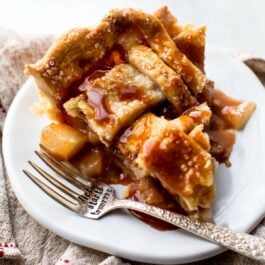 slice of caramel pear pie on a white plate with a fork