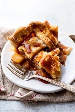 slice of caramel pear pie on a white plate with a fork