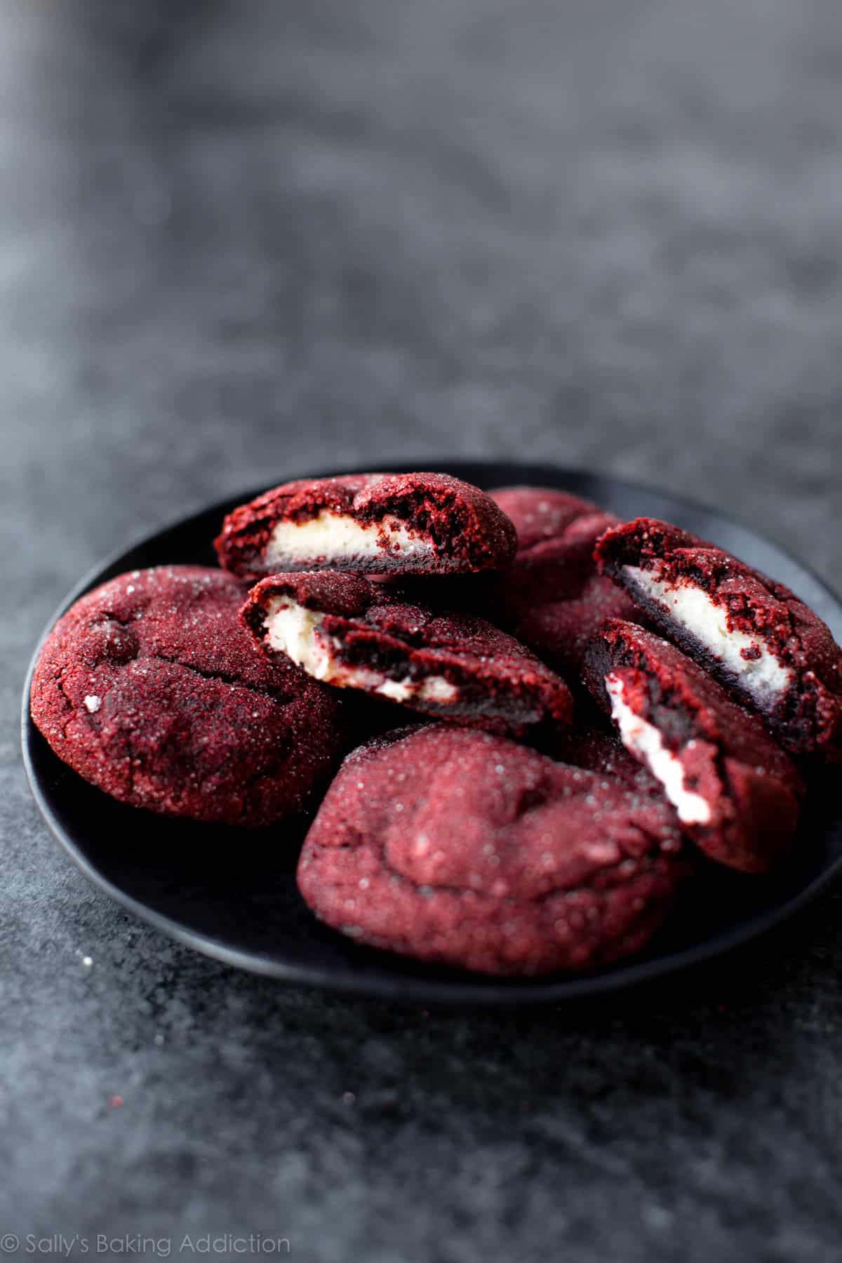cream cheese stuffed red velvet cookies on a black plate