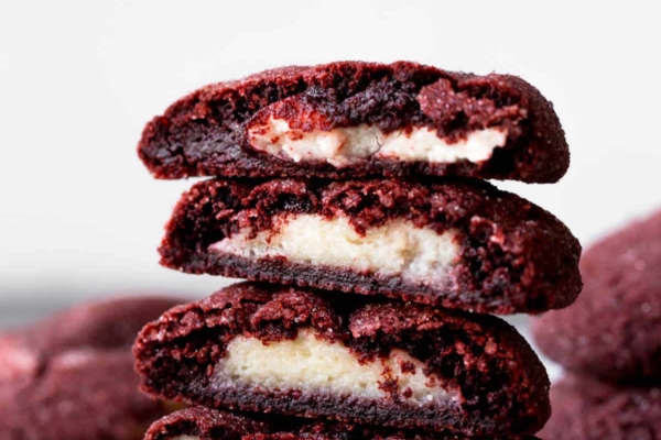 stack of cream cheese stuffed red velvet cookies showing the inside filling