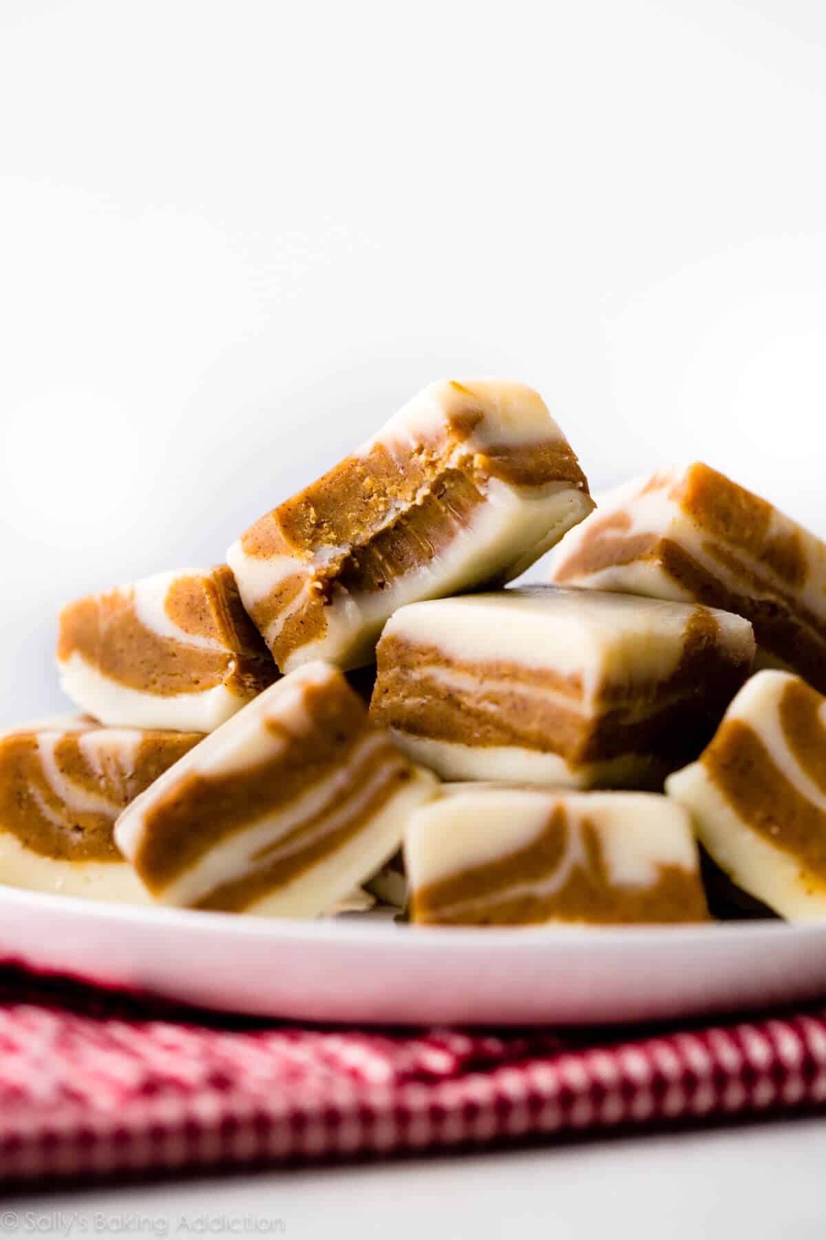 squares of gingerbread fudge stacked onto a white plate