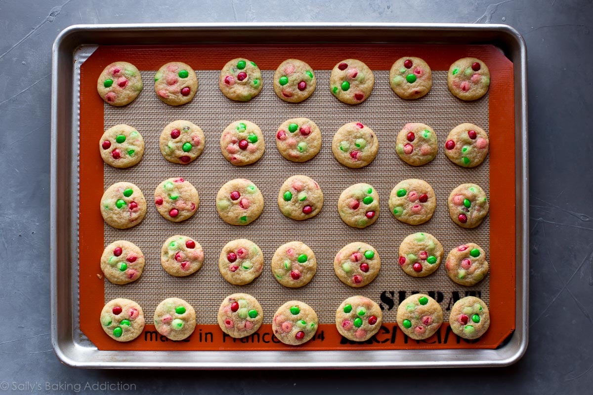 mini M&M cookies with Christmas M&Ms on a baking sheet after baking