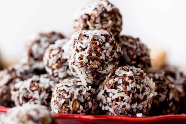 stack of no-bake chocolate coconut snowballs on a red plate