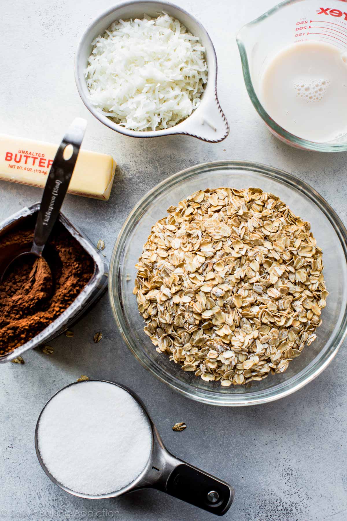 ingredients for no-bake chocolate coconut snowballs in bowls and measuring cups