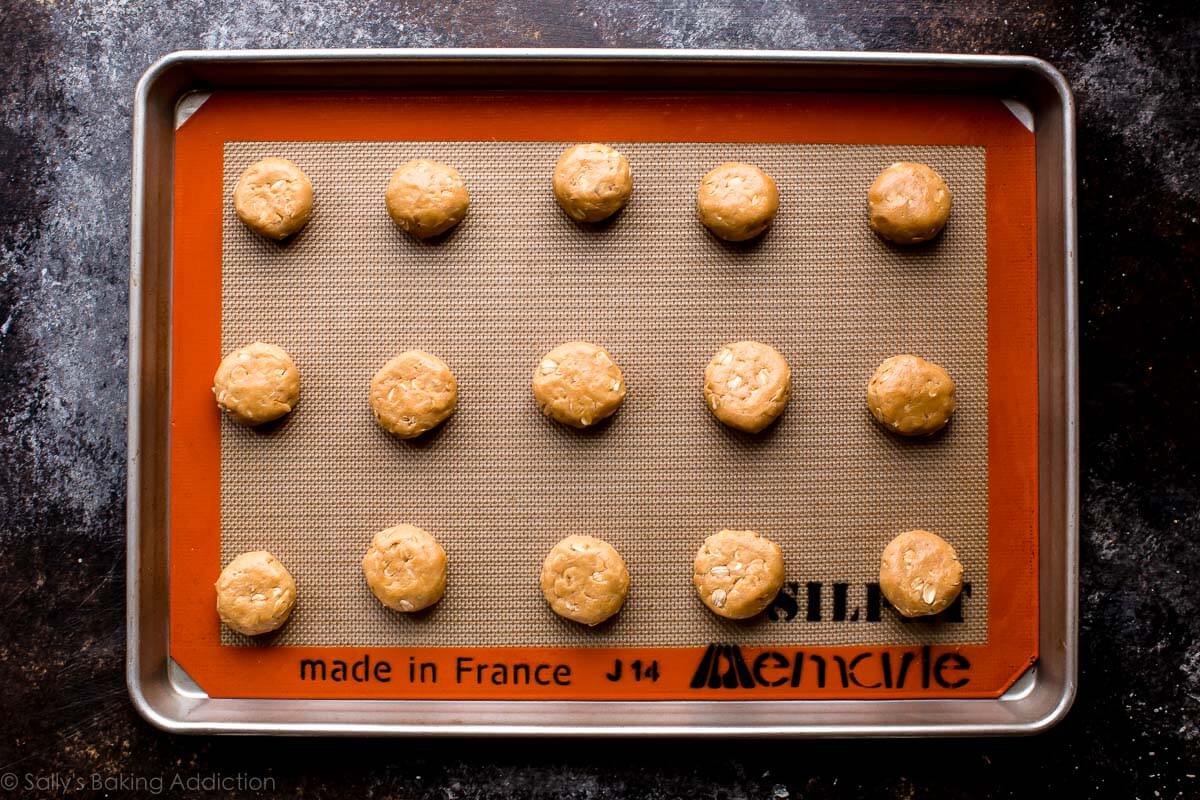 peanut butter cookie dough balls on a baking sheet