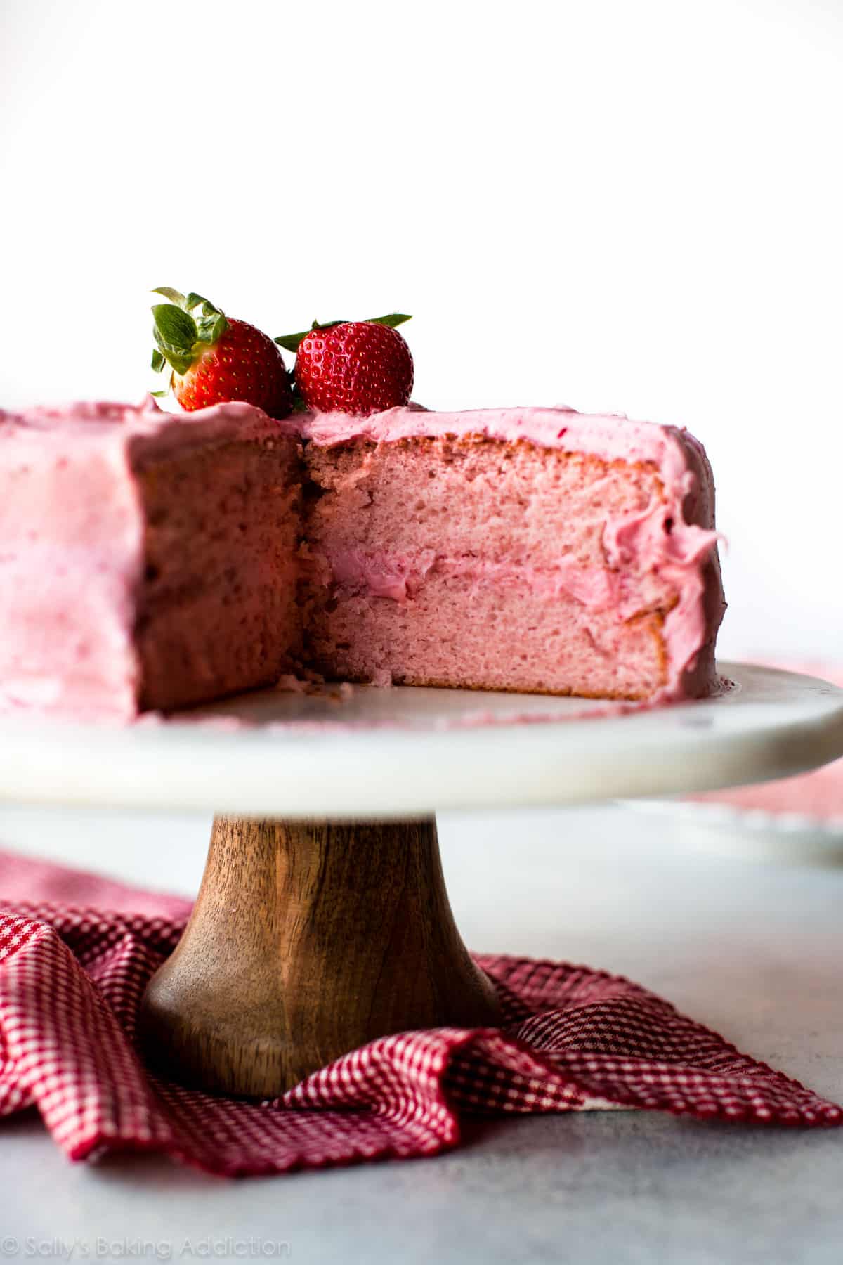 Homemade strawberry cake on a wood and marble cake stand