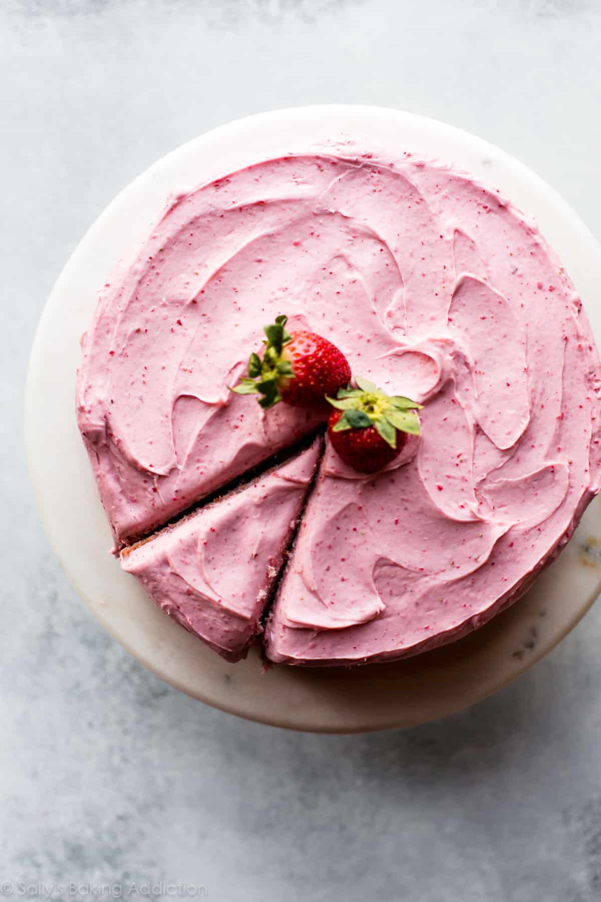 Top photo of homemade strawberry cake on a marble cake stand