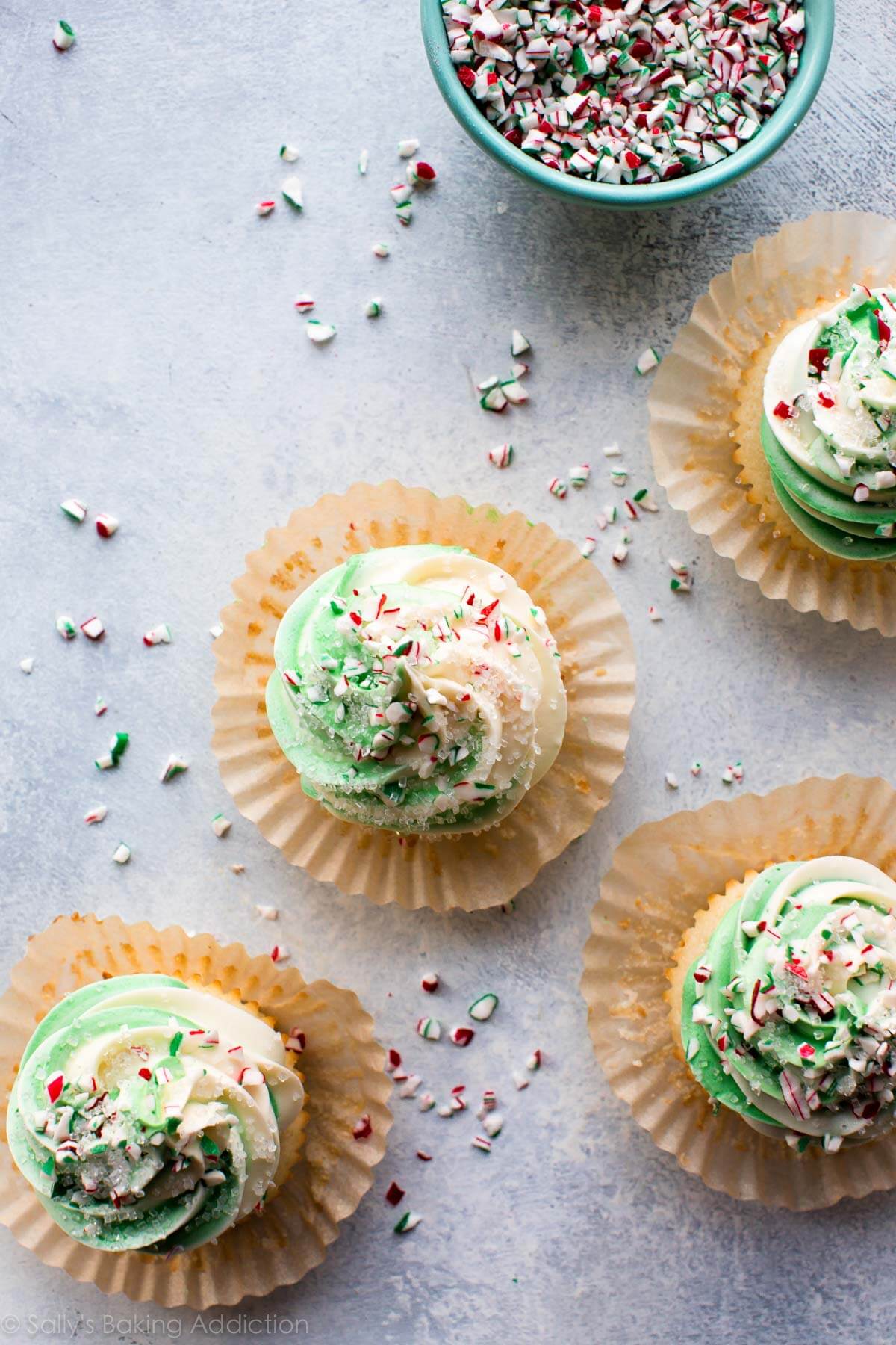 overhead image of peppermint cupcakes with white and green swirled white chocolate frosting with crushed candy canes and sprinkles