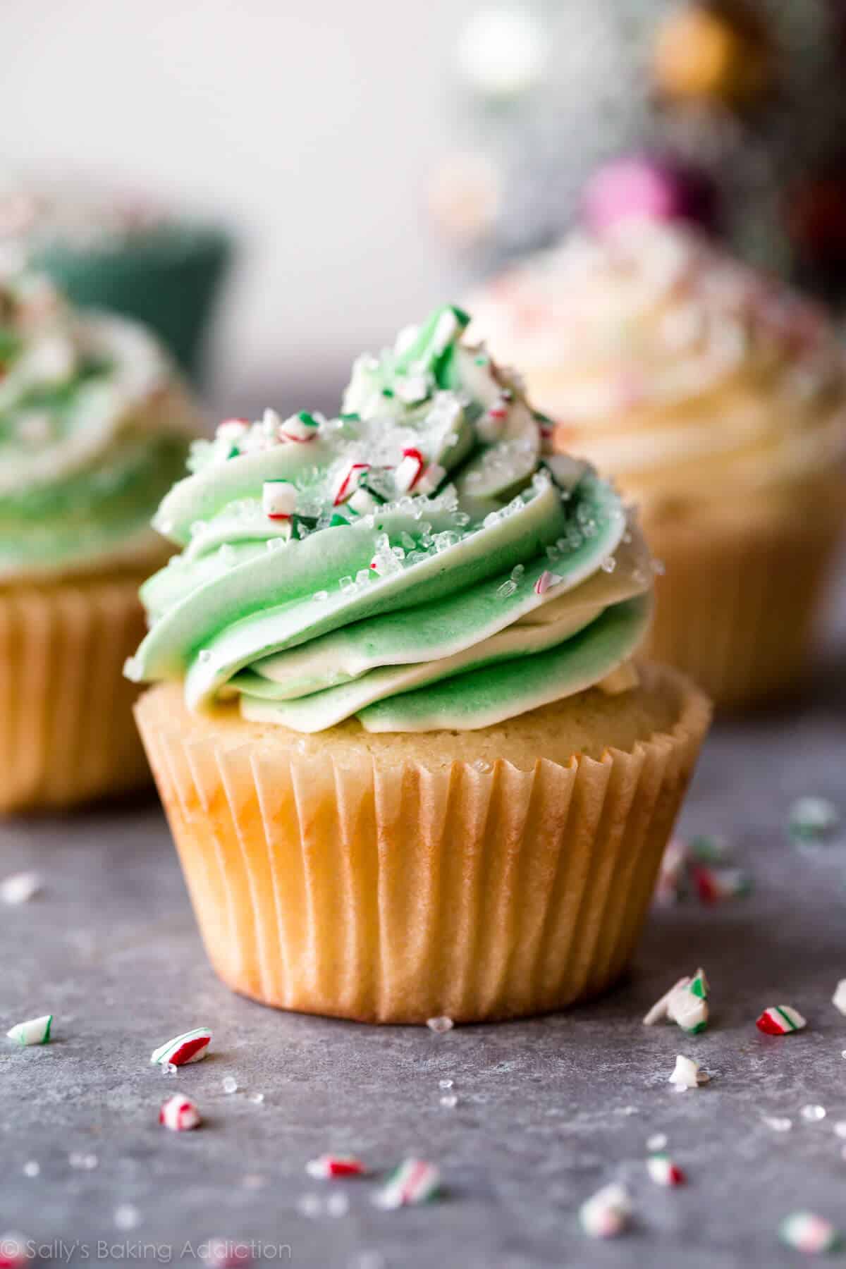 peppermint cupcake with white and green swirled white chocolate frosting with crushed candy canes and sprinkles
