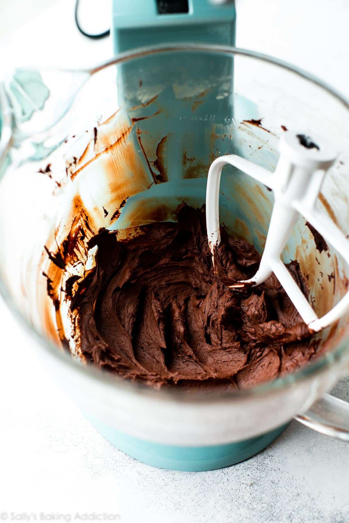 chocolate frosting in a glass stand mixer bowl