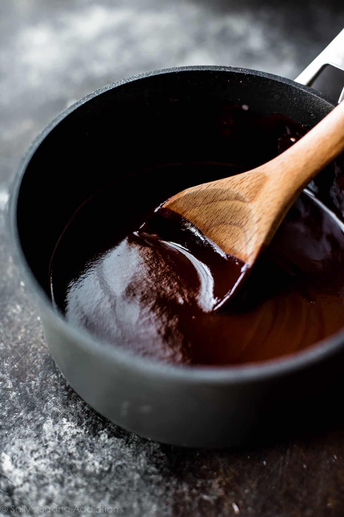 red wine chocolate ganache in a saucepan with a wood spoon
