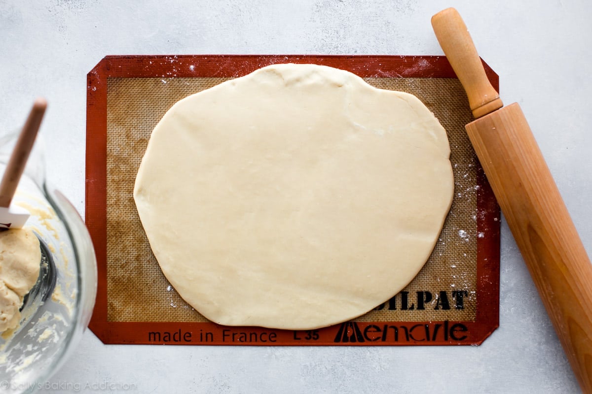 cream cheese sugar cookie dough rolled out onto a silpat baking mat