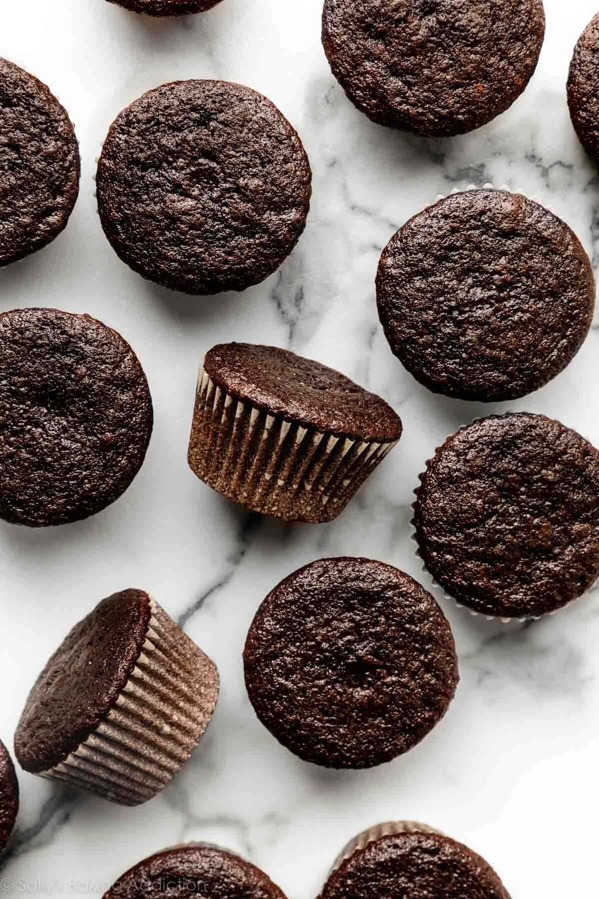plain unfrosted chocolate cupcakes on marble counter.