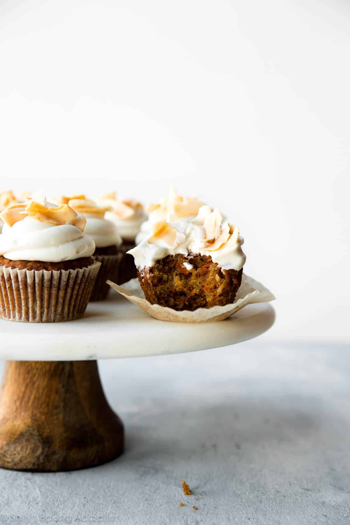 carrot cake cupcakes on a marble and wood cake stand