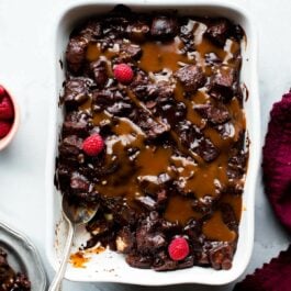 overhead image of dark chocolate bread pudding with salted caramel in a white baking dish