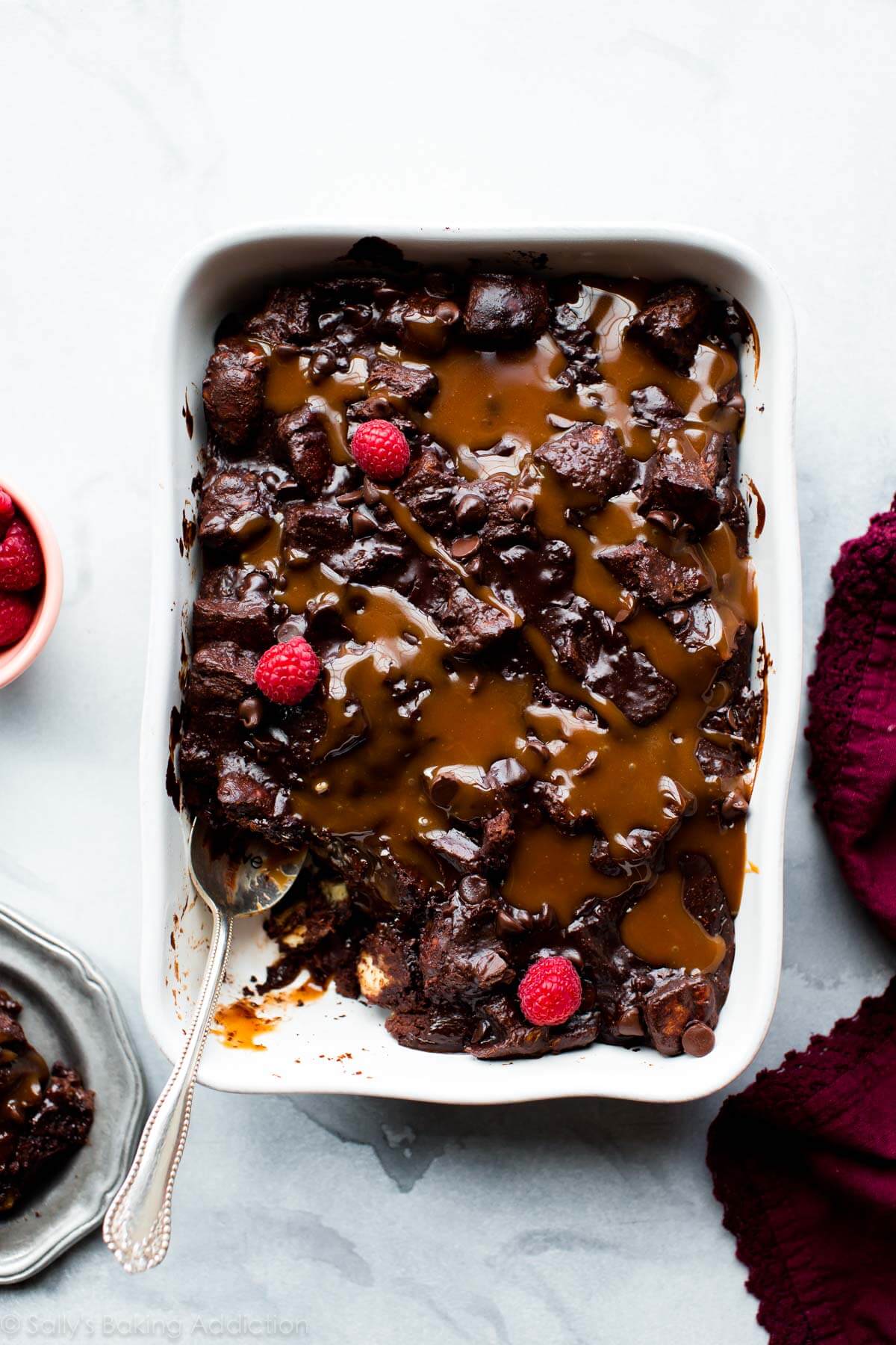 overhead image of dark chocolate bread pudding with salted caramel in a white baking dish