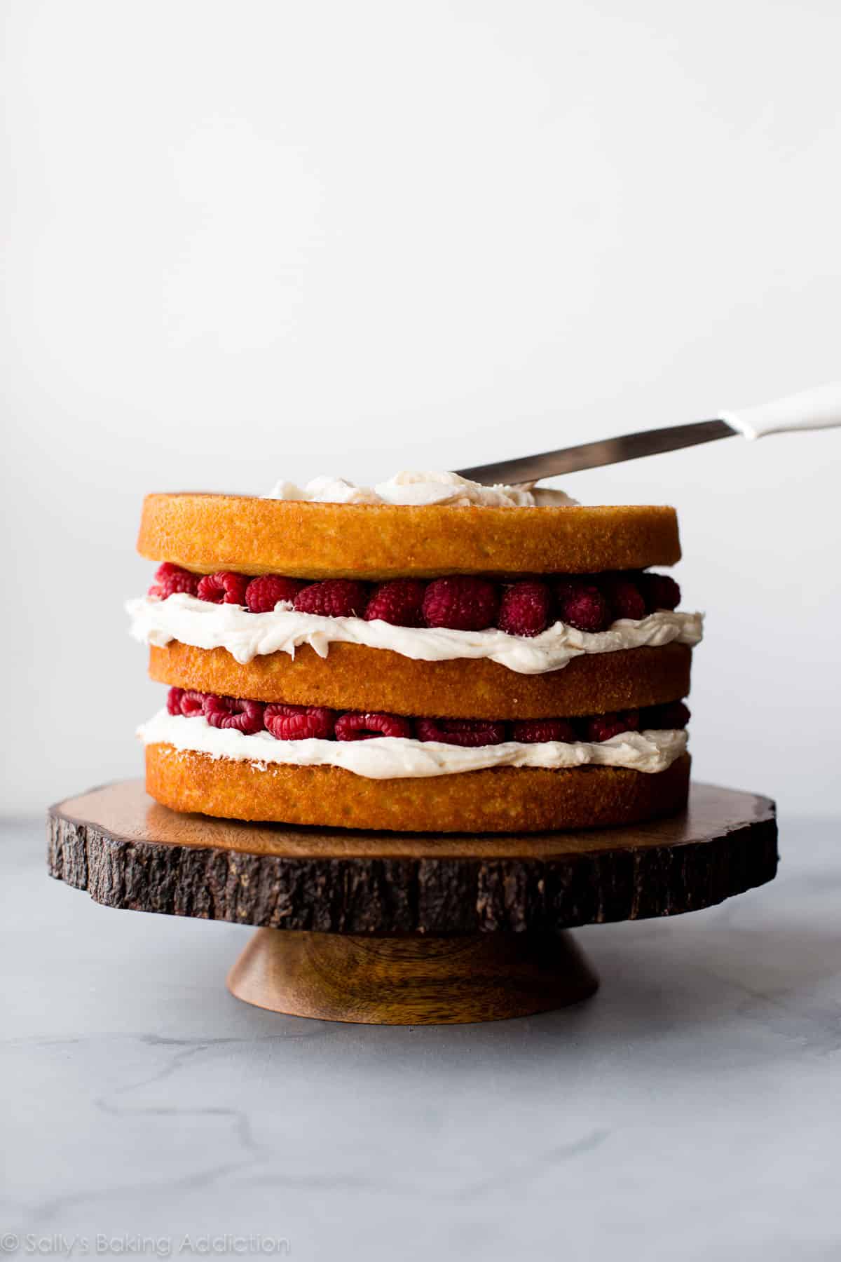 vanilla cake layers with frosting and raspberries between each layer
