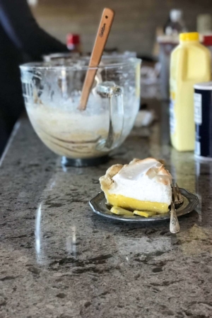lemon meringue pie on a silver plate on the kitchen counter