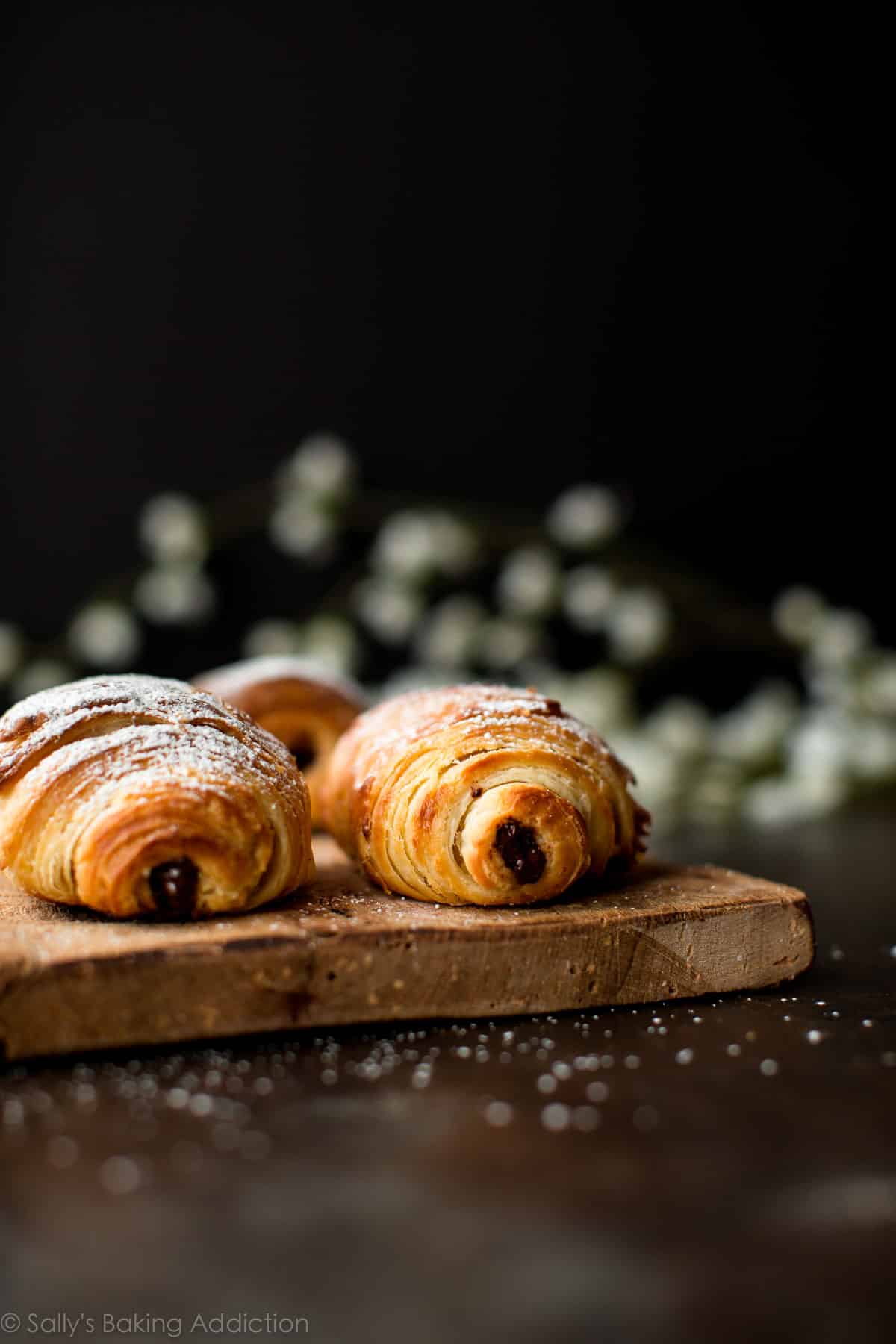 chocolate croissants on a wood serving tray