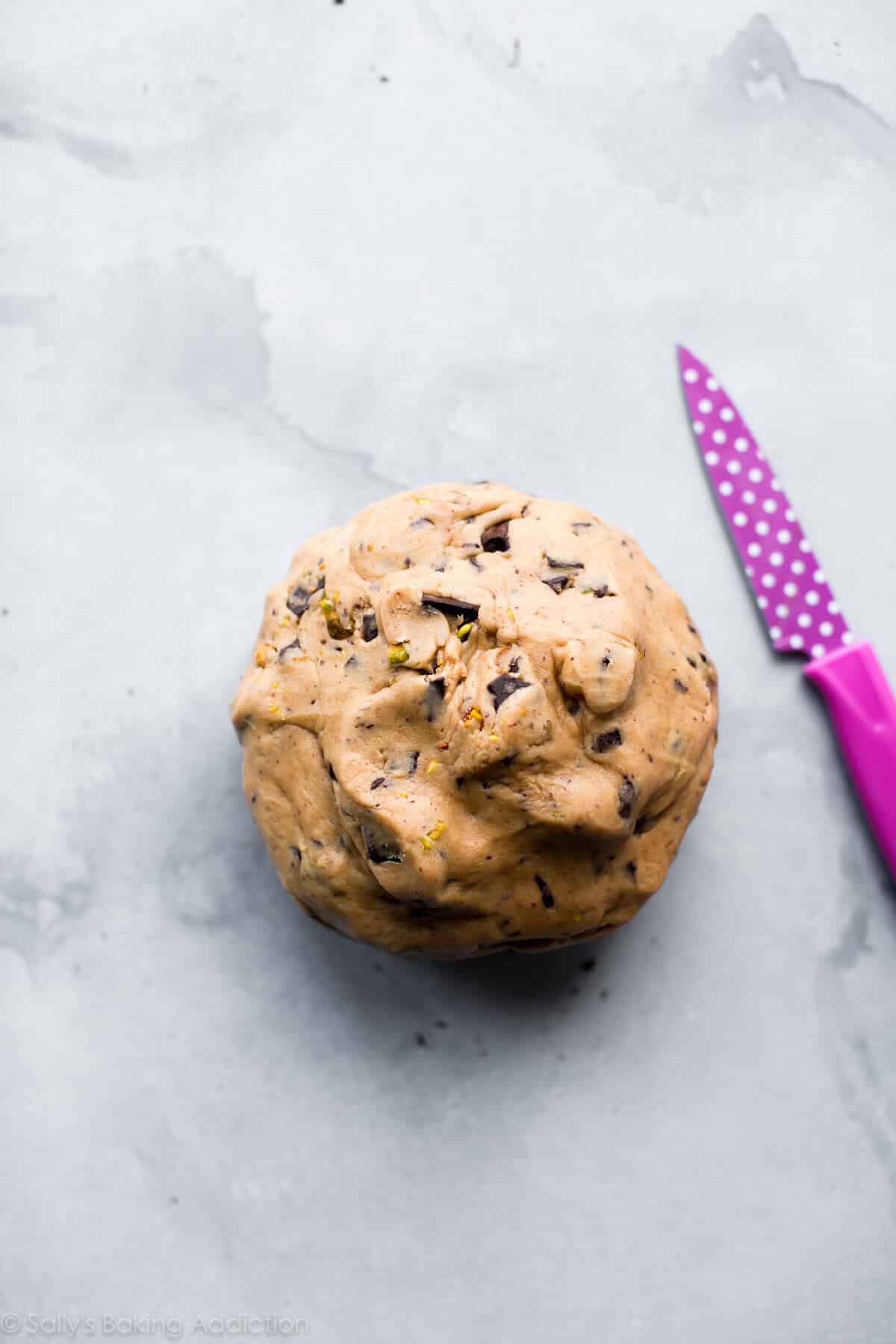pistachio chocolate chunk cookie dough rolled into a ball