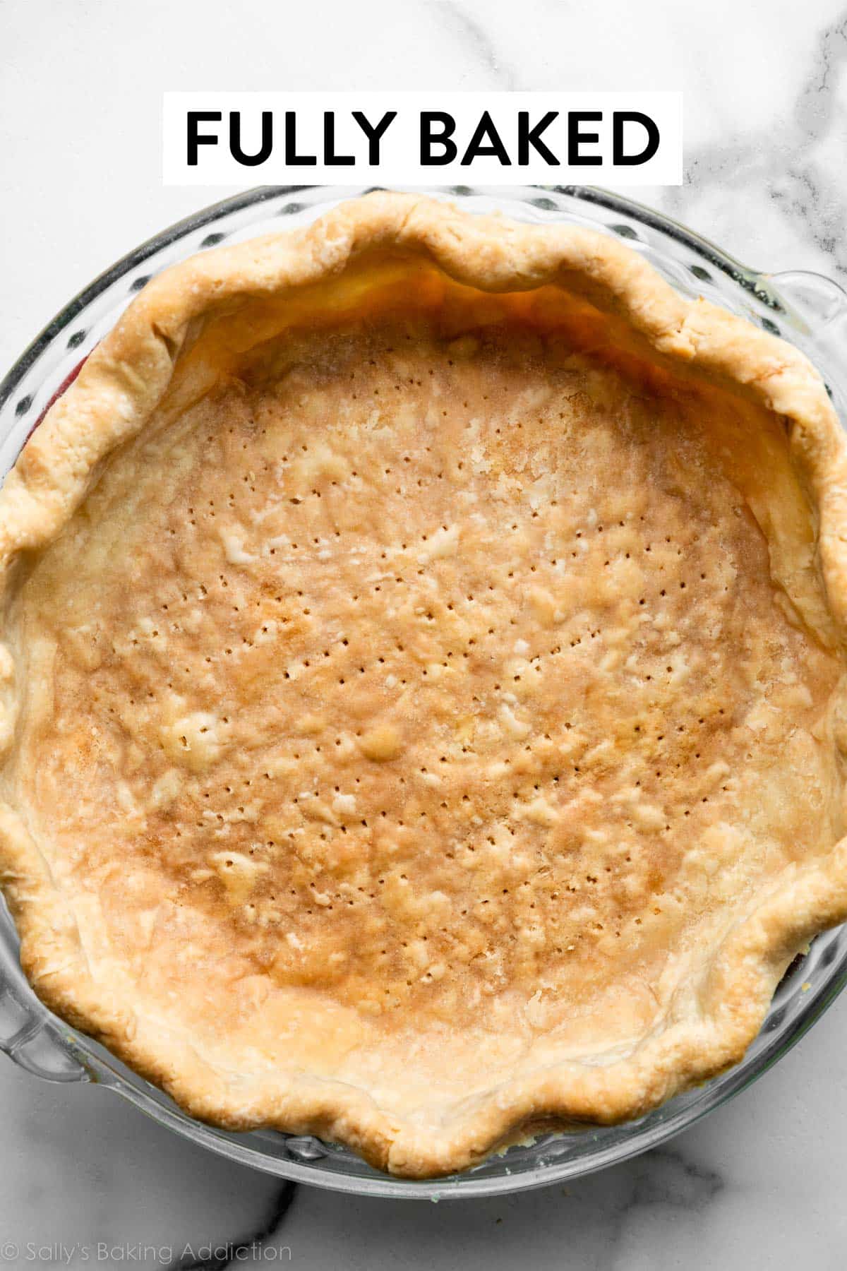 fully baked pie crust shell in glass pie dish.