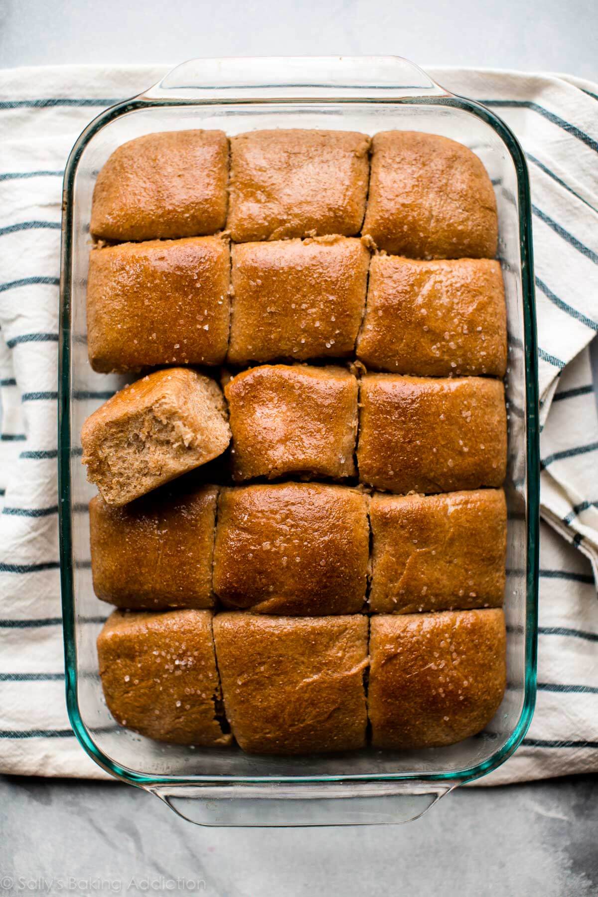 overhead image of whole wheat dinner rolls in a glass baking dish after baking