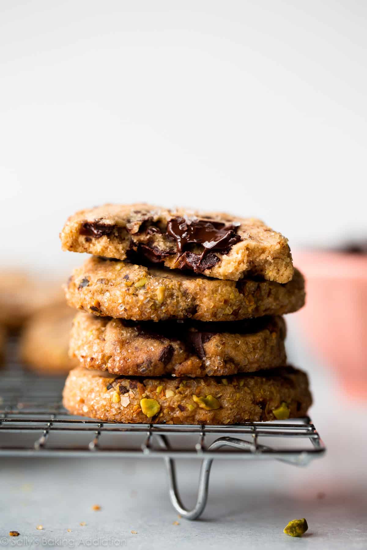 stack of pistachio chocolate chunk cookies on a cooling rack