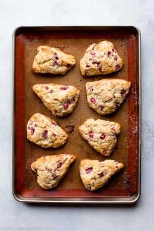 overhead image of strawberry lemon poppy seed scones on a silpat baking mat on a baking sheet