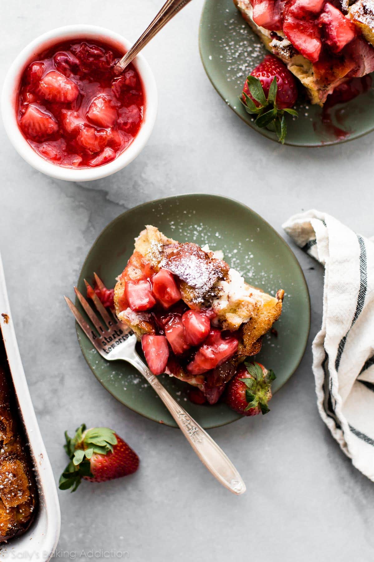 strawberry French toast bake on green plate with strawberry dessert topping