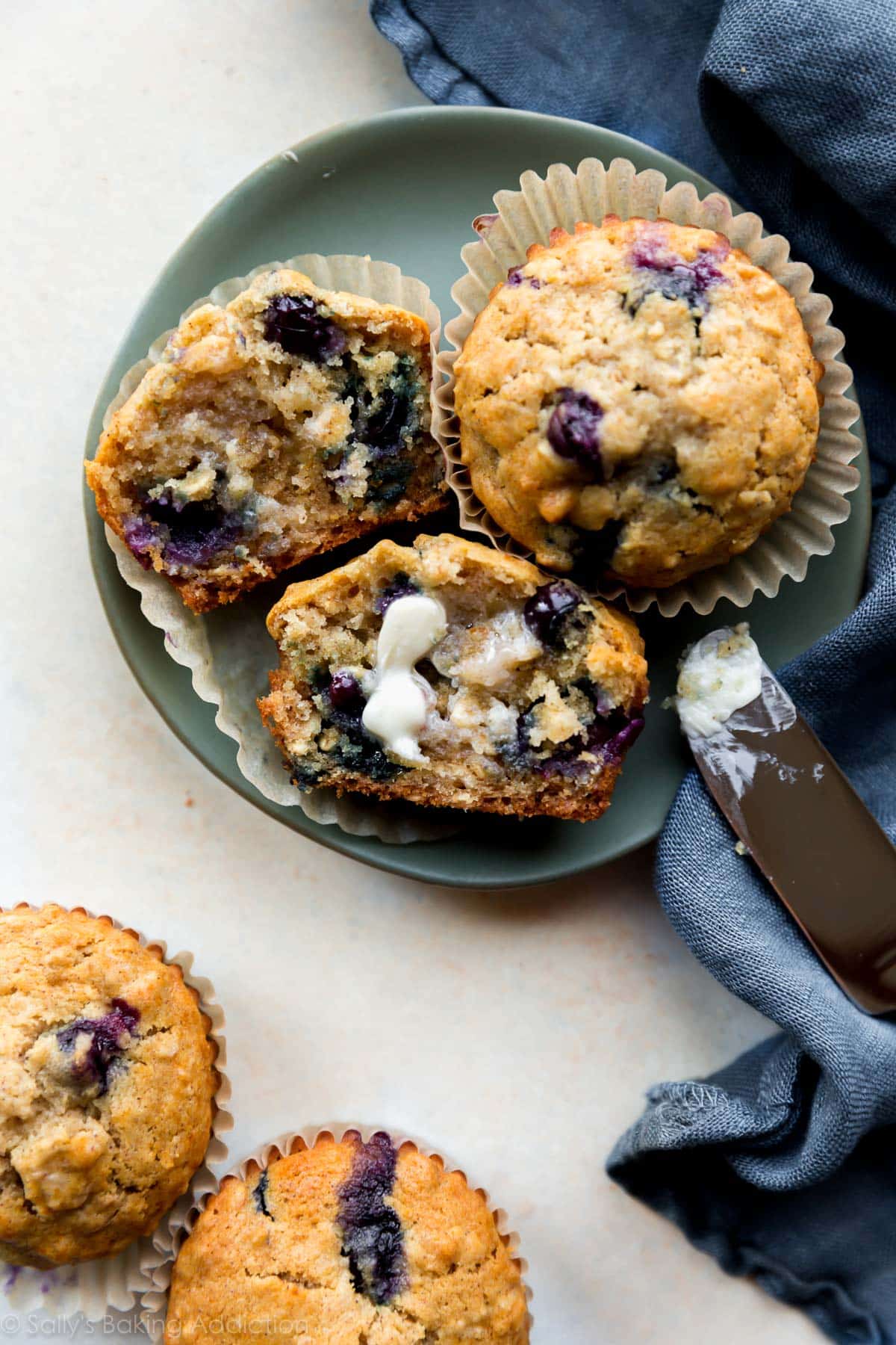 Blueberry oatmeal muffins with butter on a green plate
