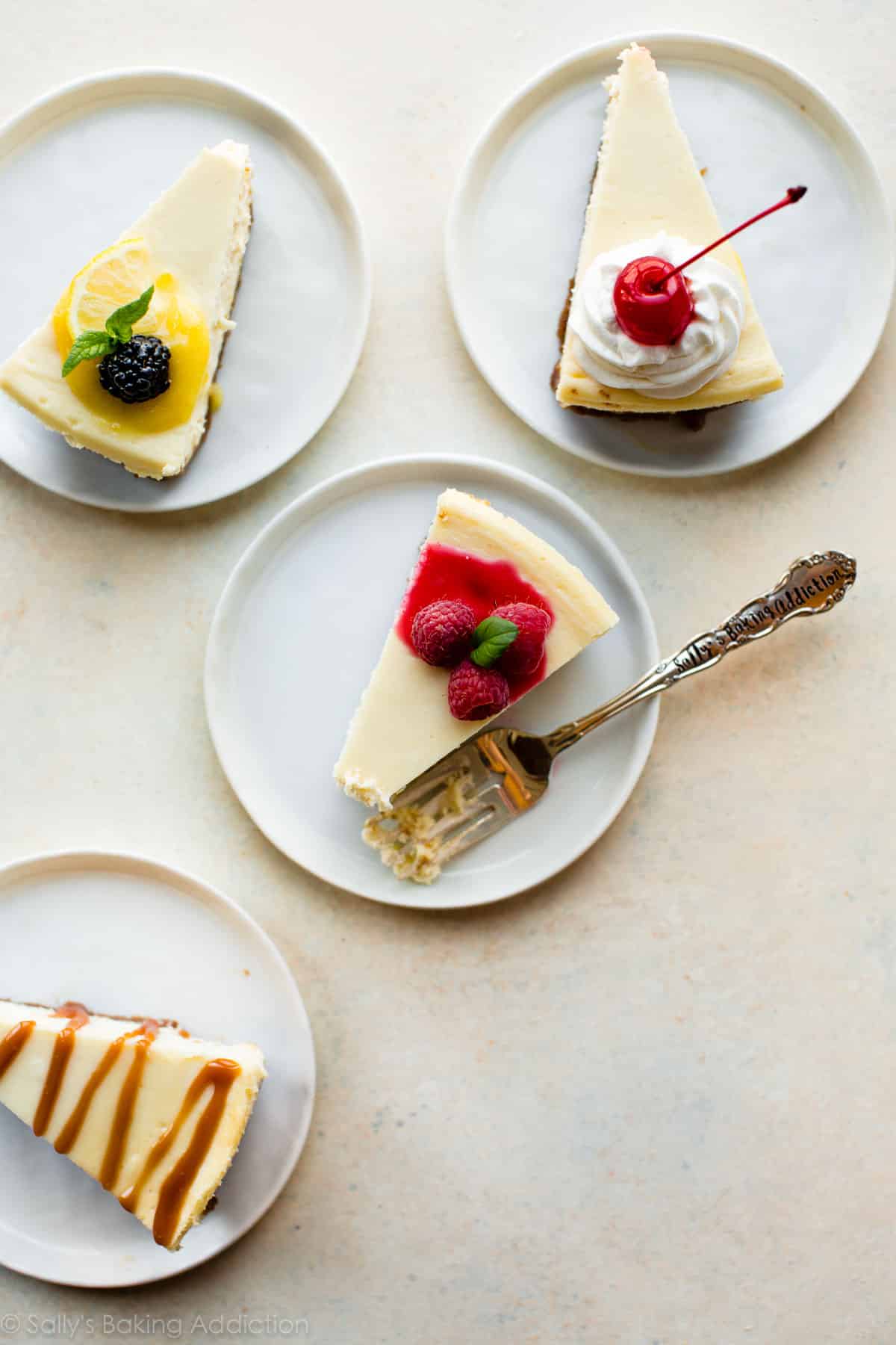 overhead image of slices of cheesecake on white plates with various toppings